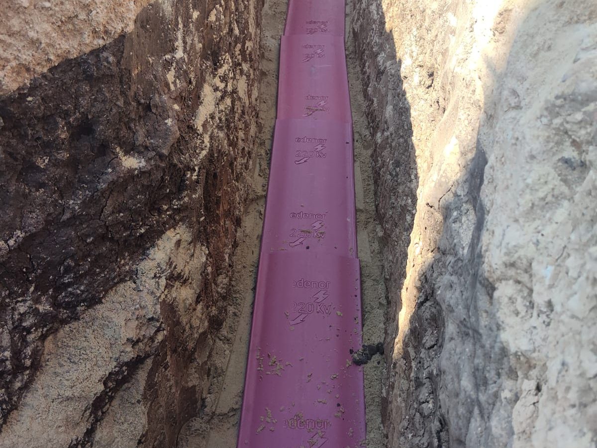 Tabla de protección de polietileno colocada sobre una canalización eléctrica dentro de la zanja